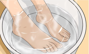 القيام بنقع القدمين في وعاء ماء دافىء